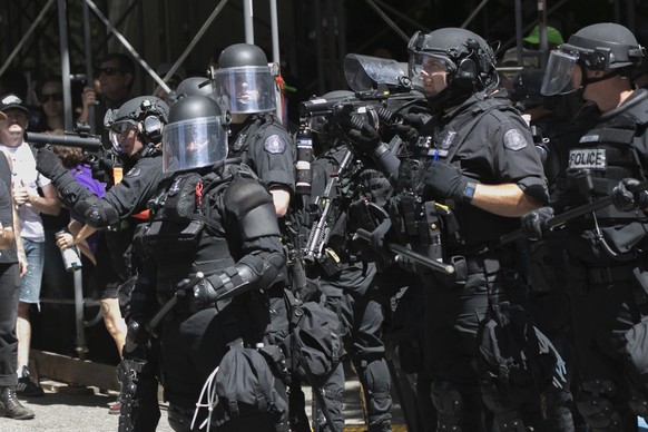 Police deploy flash bang grenades during a rally in Portland, Ore., Saturday, Aug. 4, 2018. Small scuffles broke out Saturday as police in Portland, Oregon, deployed &quot;flash bang&quot; devices and ...