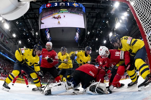 From left: Sweden's Ivar Stenberg, Switzerland's Christian Marti, Sweden's Jack Berglund, Sweden's Jacob de la Rose, Switzerland's goaltender Leonardo Genoni, Switzerland' ...