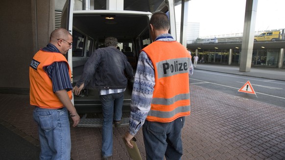 Ein, wegen Diebstahls im Kanton Bern verurteilter Pole steigt am 23. August 2006 vor der Polizeistation auf dem Flughafen Zuerich-Kloten in ein Polizeiauto, das ihn zum Flugzeug bringt, mit dem er nac ...