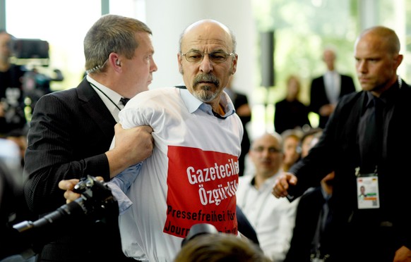 epa07053990 Turkish-German journalist identified as Ertugrul Yigit of Avrupa Postasi wearing a shirt with an inscription demanding the release of imprisioned journalists in Turkey is lead away by secu ...