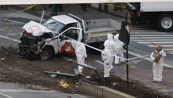 Authorities stand near a damaged Home Depot truck after a motorist drove onto a bike path near the World Trade Center memorial, striking and killing several people Tuesday, Oct. 31, 2017, in New York. ...