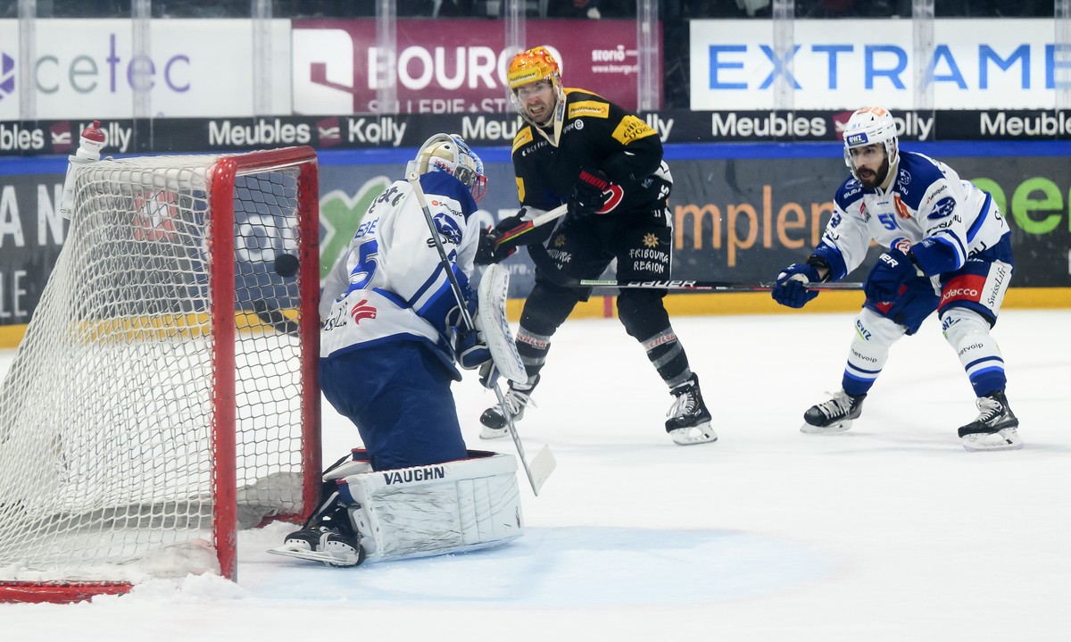 Le top scorer PostFinance fribourgeois Christopher DiDomenico, au centre, marque un goal (1-1) contre le gardien des ZSC Ludovic Waeber, a gauche, et l'attaquant des ZSC Justin Azevedo, a droite, ...
