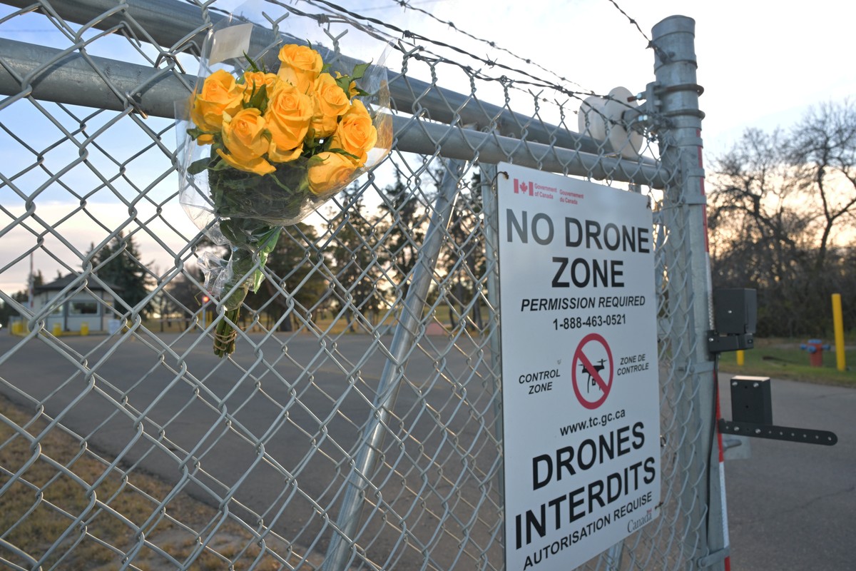 epa13314729 A bouquet of flowers sits on the fence by the main entrance to the military base in Wainwright, Alberta, Canada, 18 October 2026. At least four people died and dozens were injured after a  ...