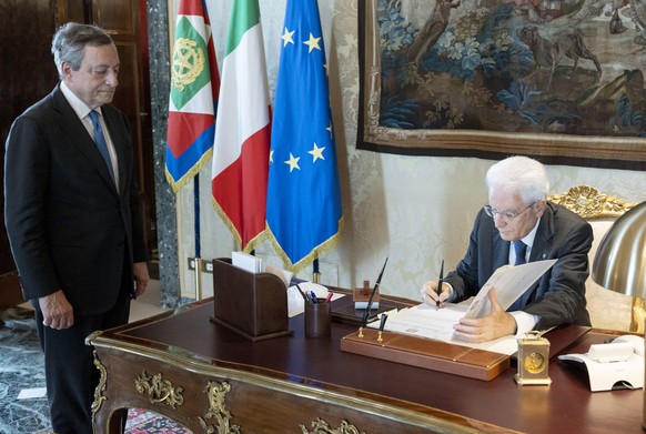 epa10084606 A handout picture made available by the Quirinal Presidential Palace (Palazzo del Quirinale) Press Office shows Italian President Sergio Mattarella signing a document as he meets with Prim ...