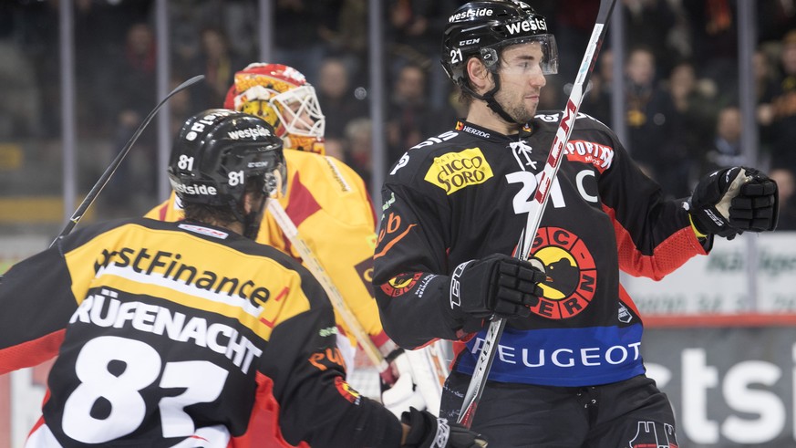 Berns Thomas Ruefenacht, links, und Torschuetze Simon Moser, rechts, jubeln Tigers Goalie Ivars Punnenovs, Mitte, geschlagen, waehrend dem Eishockey National League Spiel zwischen dem SC Bern und den  ...