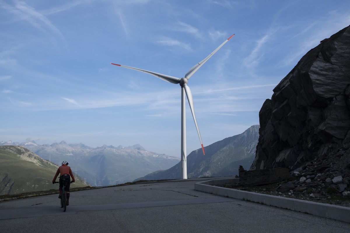 Ein Mountainbiker im Aufstieg zum Cornopass mit Blick auf ein Windrad des Windpark Gries, am Donnerstag, 22. August 2024, im Obergoms. (KEYSTONE/Gian Ehrenzeller)