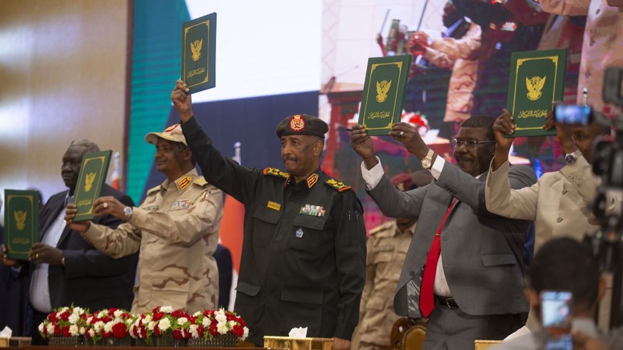 KHARTOUM, SUDAN - DECEMBER 05: Head of Sudanâs ruling Sovereign Council and Commander-In-Chief of the Sudanese Armed Forces Abdel Fattah al-Burhan (C) and his Deputy Mohamed Hamdan Dagalo (L) attend t ...