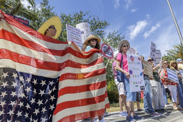 epa11982074 Activists attend a protest 'Tesla Takedown' in front of a Tesla showroom in Fort Lauderdale, Florida, USA, 22 March 2025. Protests outside Tesla showrooms in several U.S. cities ...