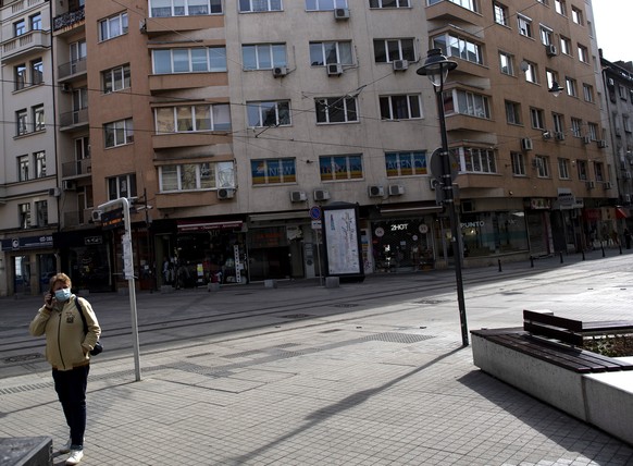 epa08293575 A woman wearing a face mask talks on the phone on a street in Sofia, Bulgaria Sofia, Bulgaria, 14 March 2020. The Bulgarian Government introduced a state of emergency as officially confirm ...