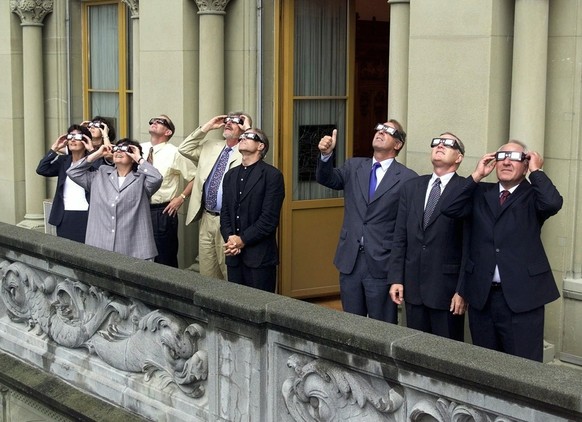 The members of the Swiss Government follow the eclipse of the sun in a balcony on the house of parliament in Berne, August 11, 1999. (KEYSTONE/Reuters Pool/Ruben Sprich)