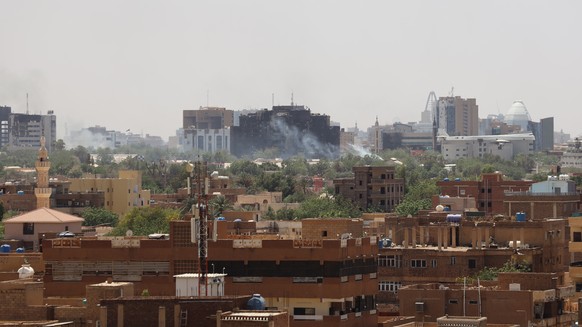 epa10578771 A civilian holds up an empty shell casing in front of a damaged window of a residential building during ongoing clashes between the Sudanese army and paramilitaries of the Rapid Support Forces...