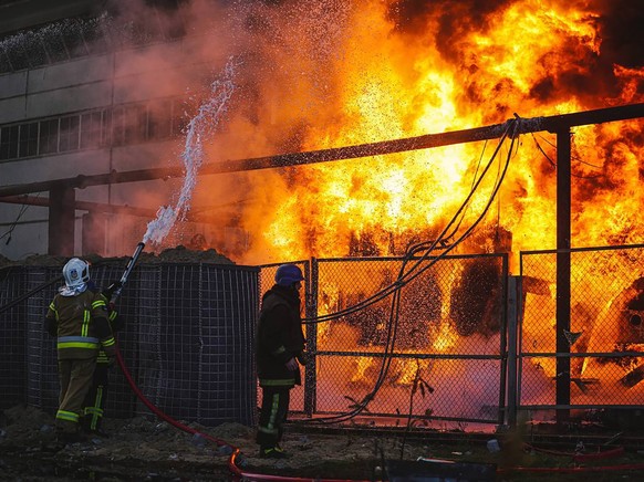 epa10250345 A handout photo released by the press service of the State Emergency Service (SES) of Ukraine shows emergency services responding to a fire after shelling in Kyiv (Kiev), Ukraine, October 18…