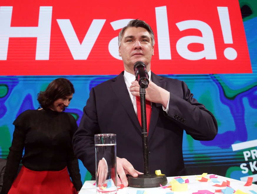 epa08105386 Croatian presidential candidate of Social Democratic Party (SDP) Zoran Milanovic (R) speaks to supporters as his wife Sanja Pusic (L) looks on during an election night rally in Zagreb, Cro ...