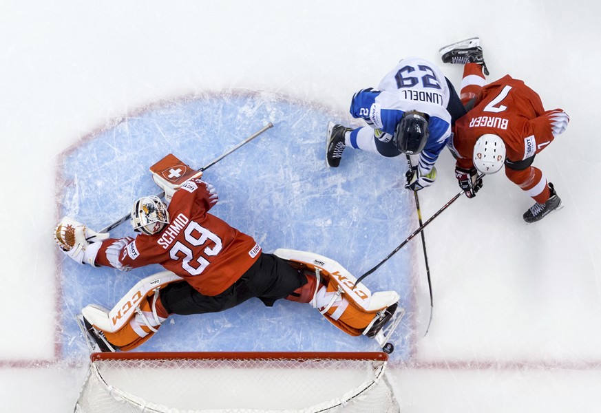 Switzerland goalie Akira Schmid, left, stops Finland&#039;s Anton Lundell, second from left, as Switzerland&#039;s Gianluca Burger, right, defends during third-period IIHF world junior semifinal hocke ...