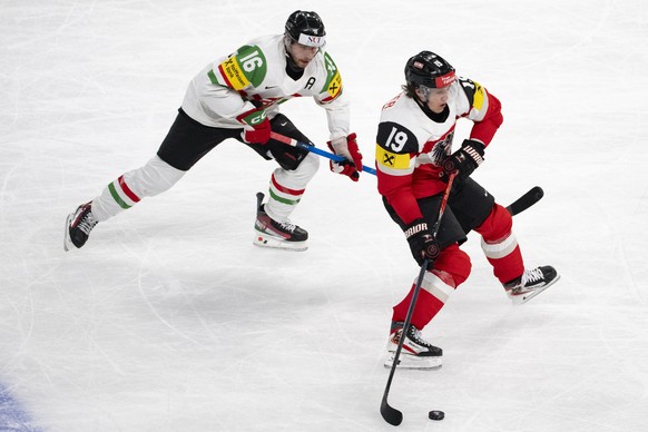 epa12968171 Austria's Vinzenz Rohrer (R) in action against Hungary's Janos Hari (L) during the 2026 IIHF Men's Ice Hockey World Championship preliminary round group A game between Austr ...