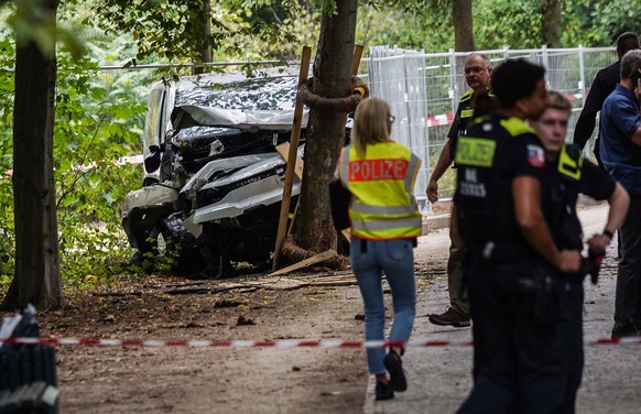 epa13133416 Police officers work next to a wrecked white vehicle in the Tiergarten area near the scene where several people were injured on the sidelines of the Christopher Street Day (CSD) parade in  ...