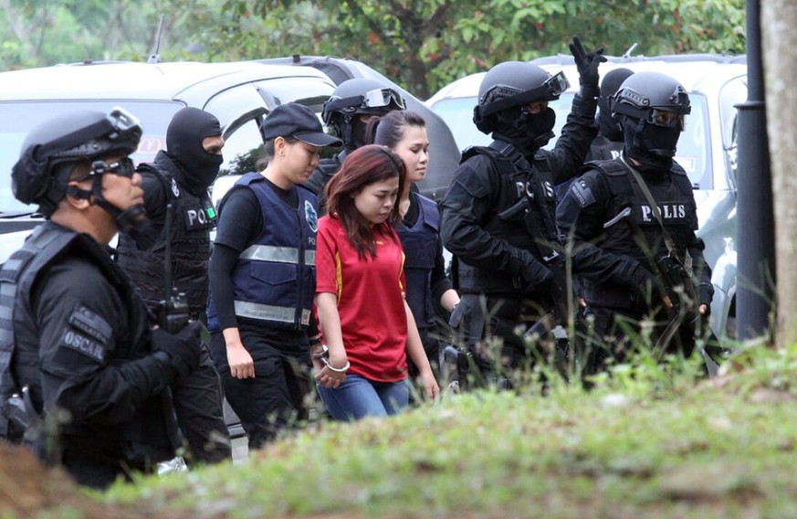 Indonesian suspect Siti Aisyah, center, in the ongoing assassination investigation, is escorted by police officers as she arrives at Sepang court in Sepang, Malaysia on Wednesday, March 1, 2017. Under ...