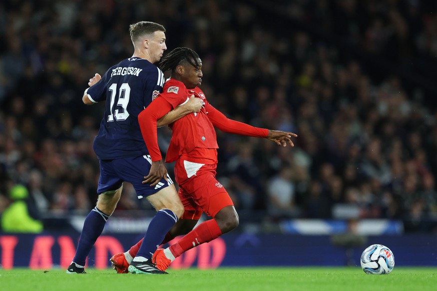 Scotland's Lewis Ferguson, left, fights for the ball with Switzerland's Johan Manzambi during the Nations League soccer match between Scotland and Switzerland in Glasgow, Scotland, Tuesday,  ...