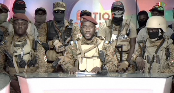 In this image from video broadcast by RTB state television, coup spokesman Capt. Kiswendsida Farouk Azaria Sorgho reads a statement in a studio in Ougadougou, Burkina Faso, on Friday evening, Sept. 30 ...