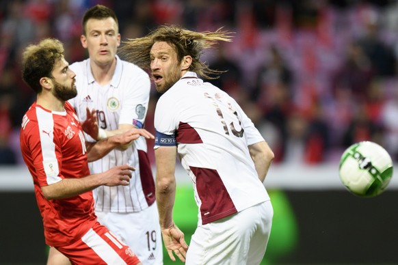 Swiss midfielder Admir Mehmedi, left, fights for the ball with Latvia&#039;s defender Vitalijs Jagodinskis, center, and Latvia&#039;s defender Kaspars Gorkss, right, during the 2018 Fifa World Cup Rus ...