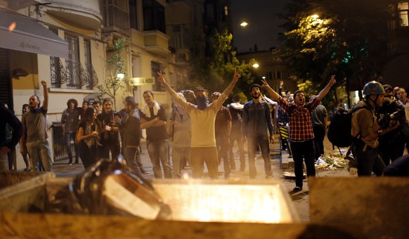 epa04234290 Protesters shouts slogans near barricade during a demonstration on the occasion of the first anniversary of the Gezi Park protests at the Taksim Square, in Istanbul, Turkey, 31 May 2014. It is the first anniversary of the Gezi Park protests in Taksim Square where a total of seven people lost their lives in the protests that began from 31 May 2013 against plans to replaceTaksim Gezi Park with a shopping mall.  EPA/SEDAT SUNA