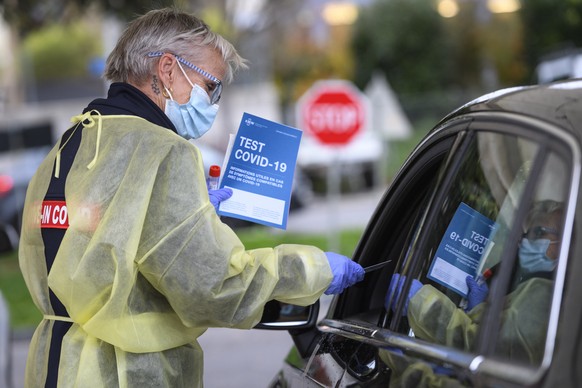 A health worker collects a nose swab sample for a polymerase chain reaction (PCR) test at a drive-in coronavirus testing facility in front of the eHnv hospital (Etablissements Hospitaliers du Nord Vau ...