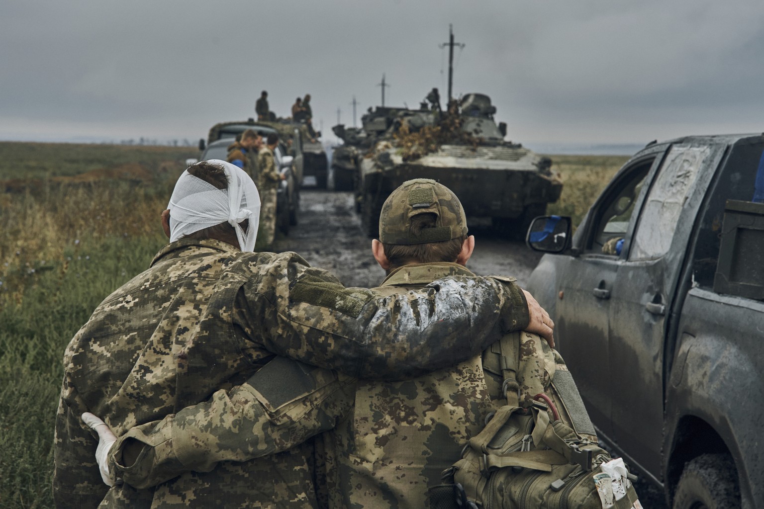 A Ukrainian soldier helps a wounded fellow soldier on the road in the freed territory in the Kharkiv region, Ukraine, Monday, Sept. 12, 2022. Ukrainian troops retook a wide swath of territory from Rus ...