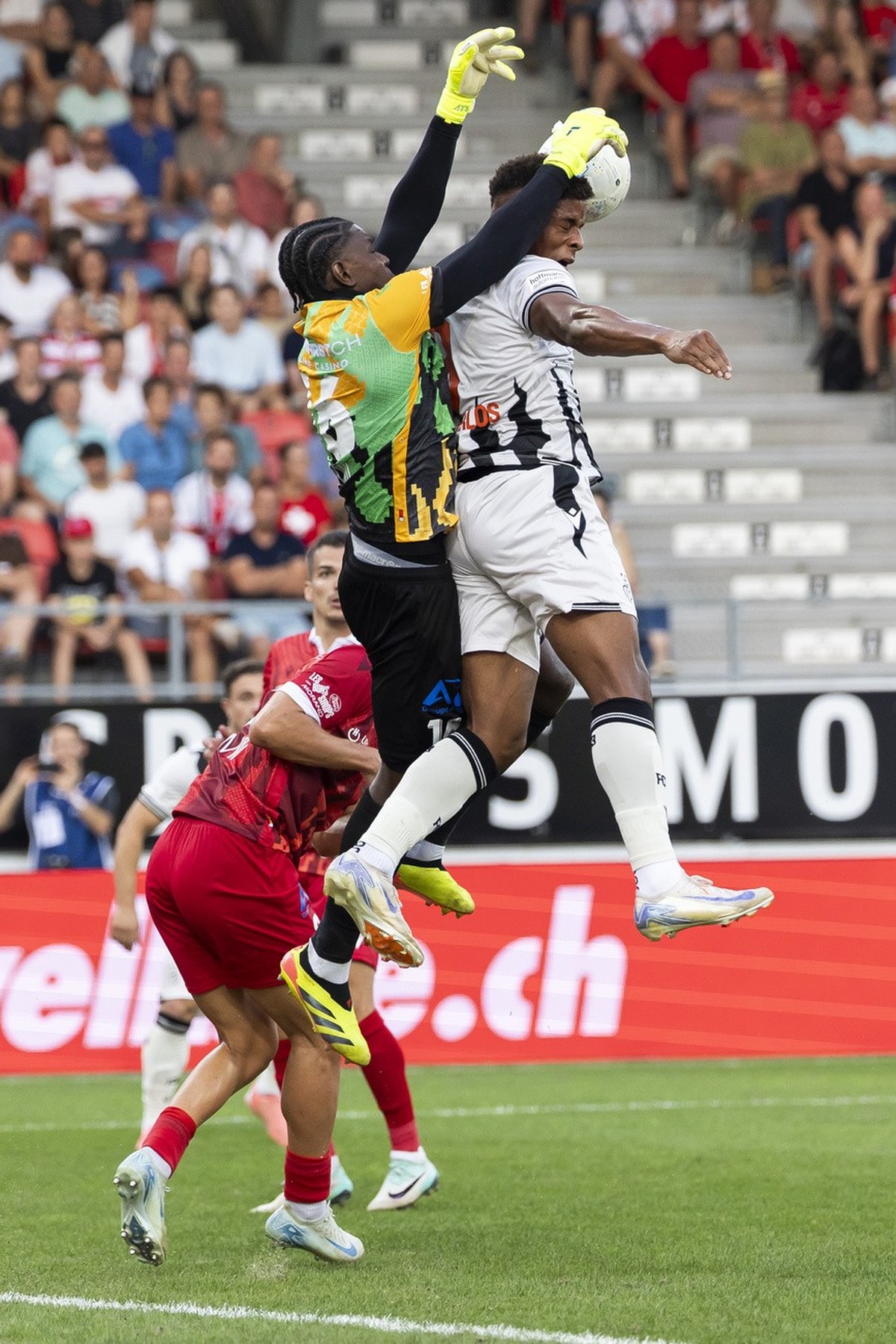 le gardien Timothy Fayulu (SIO), gauche, lutte pour le ballon avec Kevin Carlos (FCB), droite, lors de la rencontre du championnat de football de Super League entre le FC Sion et le FC Bale ce samedi, ...