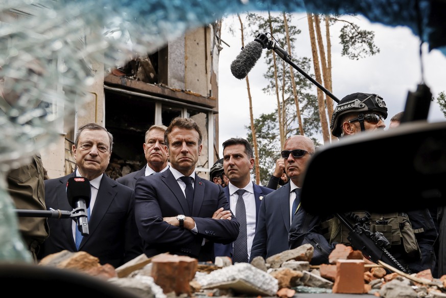 Italian Prime Minister Mario Draghi, left, and French President Emmanuel Macron watch debris as they visit Irpin, outside Kyiv, Thursday, June 16, 2022. The leaders of France, Germany, Italy and Roman ...