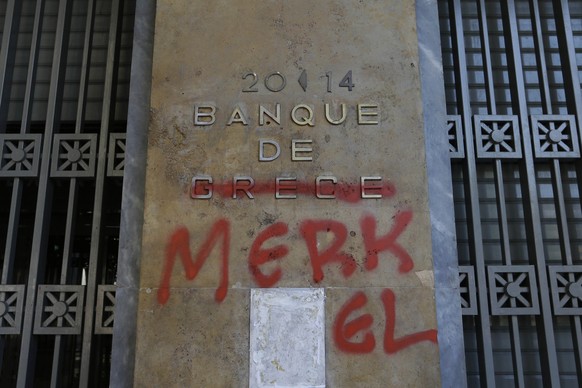 Red spray paint covers a French-language Bank of Greece sign to read &#039;Bank of Merkel&#039; in reference to German Chancellor Angela Merkel in Athens, Monday, July 6, 2015. Greek Finance Minister  ...