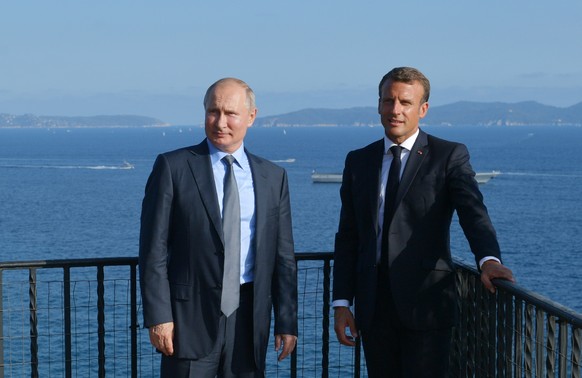 FILE - French President Emmanuel Macron, right, and Russian President Vladimir Putin pose for a photo during their meeting at the fort of Bregancon in Bormes-les-Mimosas, southern France, on Aug. 19,  ...