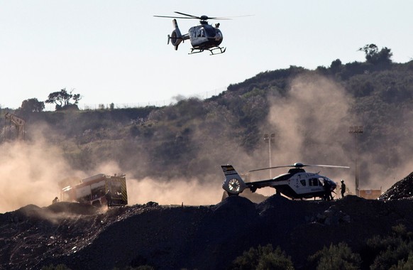 epa07319074 Helicopters of the Spanish Civil Guard reportedly carrying explosive materials arrive at the site where rescue teams continue their works to find two-year-old boy Julen who fell down a 110 ...