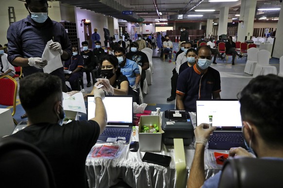 People register for a polymerase chain reaction (PCR) test at the Guru Nanak Darbar Sikh Temple, in Dubai, United Arab Emirates, Monday, Feb. 8, 2021. With the coronavirus pandemic surging to new heig ...