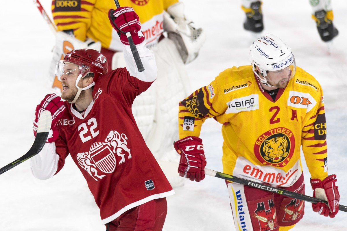 L'attaquant lausannois Christoph Bertschy, gauche, celebre le premier goal devant la deception du defenseur de Langnau Federico Lardi, droite, lors de la rencontre du championnat suisse de hockey ...
