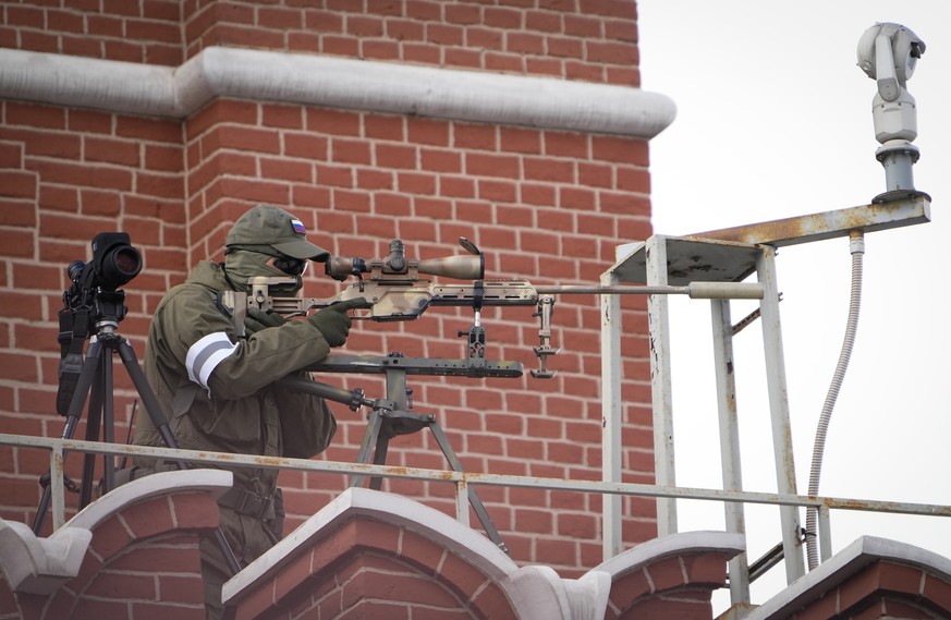 A security service officer aims his sniper rifle securing the area during the Victory Day military parade in Moscow, Russia, Monday, May 9, 2022, marking the 77th anniversary of the end of World War I ...