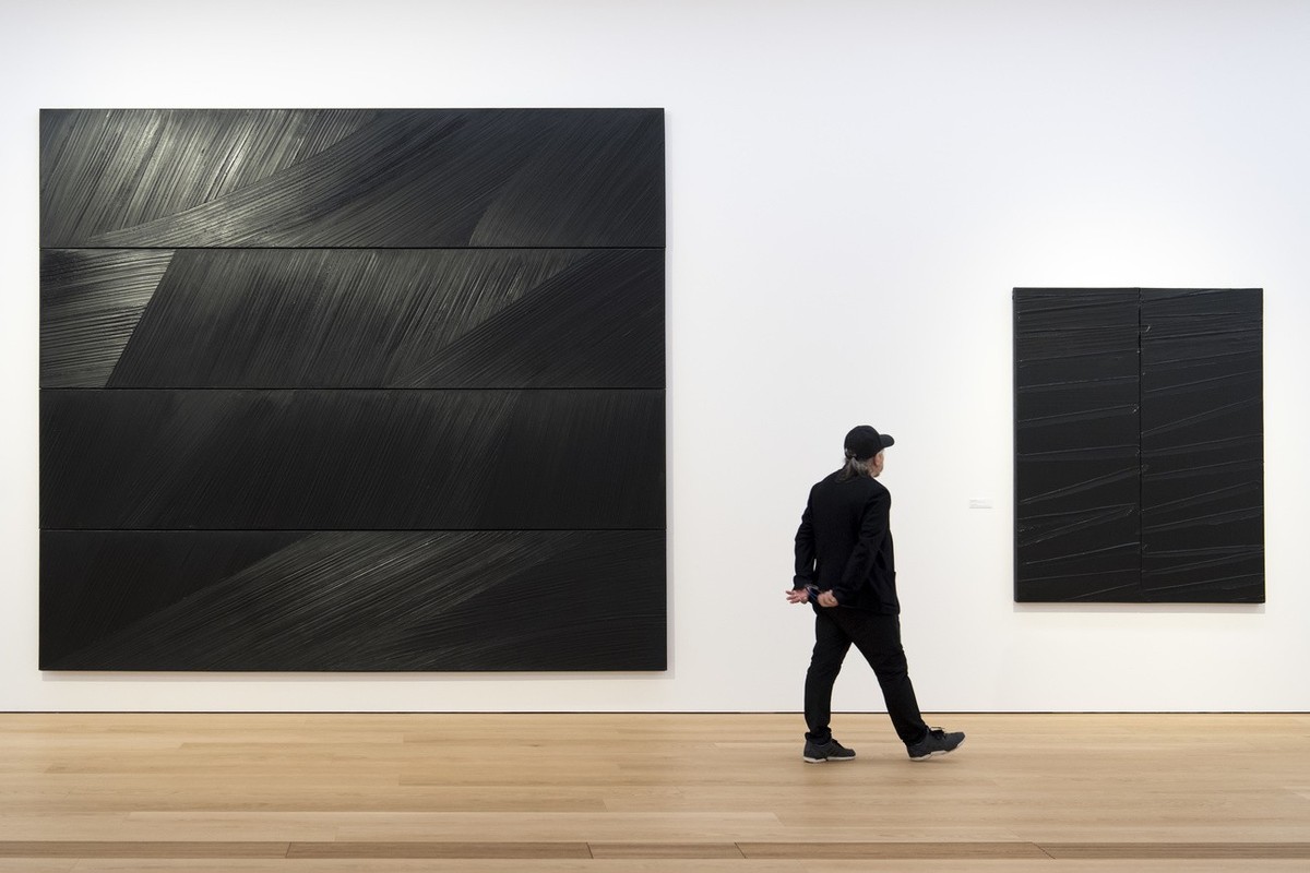 Une personne observe deux tableaux du peintre Pierre Soulages lors de la presentation a la presse de l'exposition inaugurale "Atlas. Cartographie du don" au nouveau Musee cantonal des B ...
