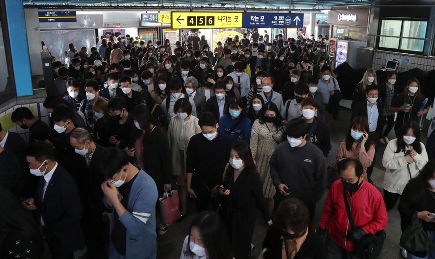 epa08413717 Commuters wearing masks change trains in the morning rush hour at a subway station in Seoul, South Korea, 11 May 2020, amid concerns over the spread of COVID-19 in the wake of new infectio ...