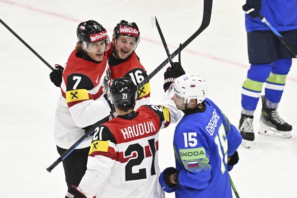 Austria&#039;s Brian Lebler, left, scores and celebrates with Dominic Zwerger and Lukas Haudum, front, during the IIHF Ice Hockey World Championship group A match between Slovenia and Austria at Avici ...