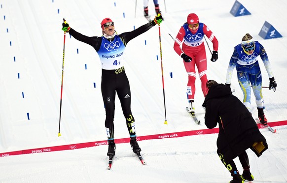 epa09761505 Victoria Carl (L) of Germany crosses the finish line winning the Women&#039;s Team Sprint final at the Zhangjiakou National Cross-Country Skiing Centre at the Beijing 2022 Olympic Games, Z ...