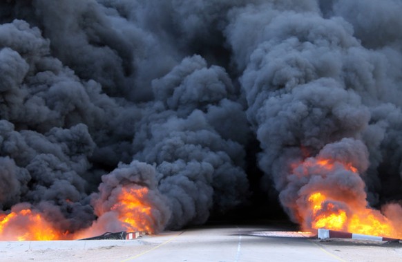 epa04541650 A picture made available 28 December 2014 shows smoke rising from a large fuel depot fire, al-Sidra, Libya, 26 December 2014. According to reports the depot was hit by a rocket attack duri ...