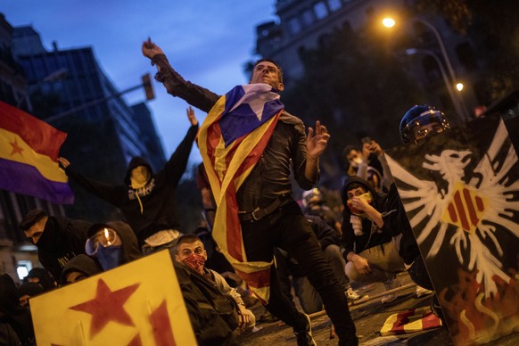 A Catalan pro-independence protestor throws a stone during clashes with police in Barcelona, Spain, Friday, Oct. 18, 2019.The Catalan regional capital is bracing for a fifth day of protests over the c ...