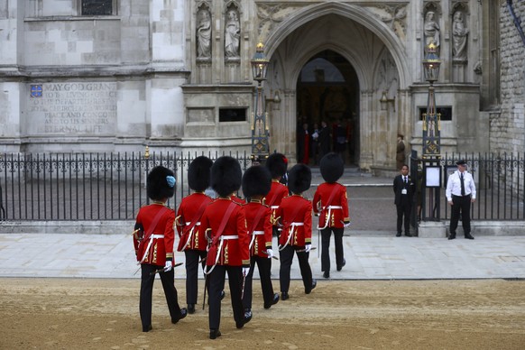 Soldiers in ceremonial uniform walk into Westminster Abbey, on the day of the Queen Elizabeth II funeral, at Westminster Abbey in London Monday, Sept. 19, 2022. (Hannah Mckay/Pool Photo via AP)