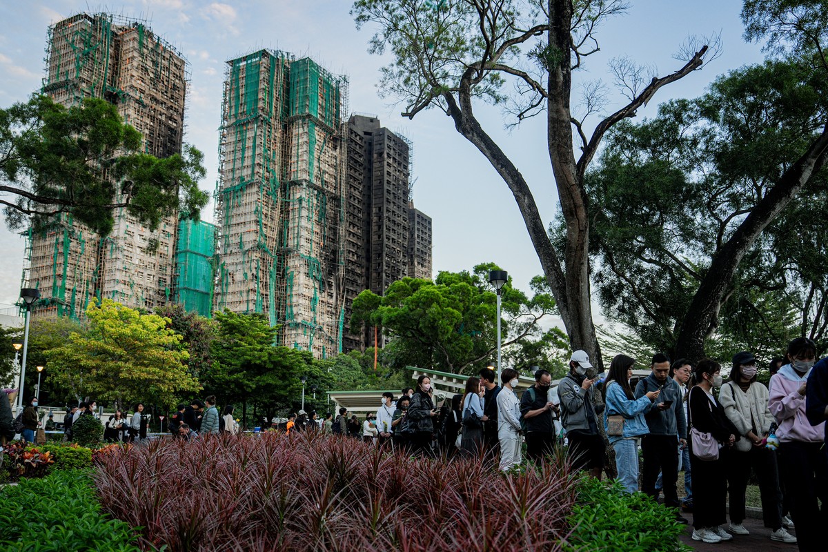 epa12556625 People lay floral tributes for the victims of the fire at the Wang Fuk Court residential estate in the Tai Po district of Hong Kong, China, 29 November 2025. The city is mourning 128 peopl ...
