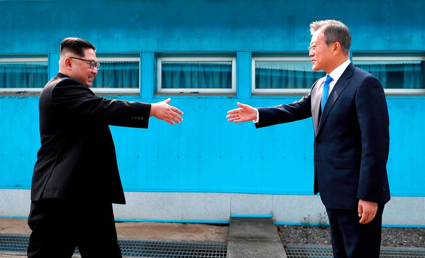 FILE - In this April 27, 2018 file photo, North Korean leader Kim Jong Un, left, prepares to shake hands with South Korean President Moon Jae-in over the military demarcation line at the border villag ...