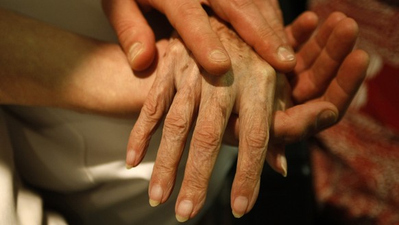 **File** Ein Pfleger massiert am 25. Oktober 2007 in einem Seniorenzentrum in Stuttgart die Hand einer alten Frau. Der Bundesgerichtshof (BGH) hat am Freitag, 25. Juni 2010, ein Grundsatzurteil zur St ...