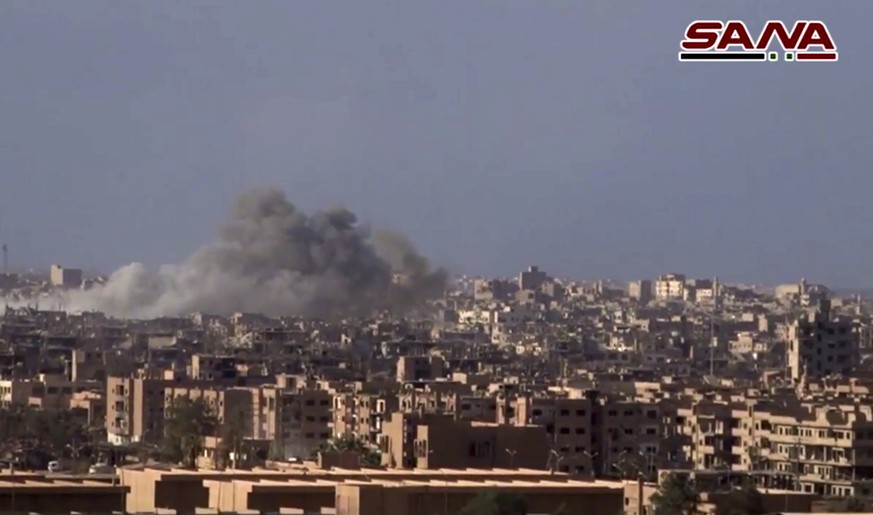 This frame grab from a video released on Nov. 2, 2017 by the Syrian official news agency SANA shows smoke and debris rising after Syrian government shelling of the Deir el-Zour city during a battle ag ...