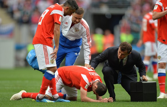 epa06807356 Alan Dzagoev (C) of Russia reacts after picking up an injury during the FIFA World Cup 2018 group A preliminary round soccer match between Russia and Saudi Arabia in Moscow, Russia, 14 Jun ...