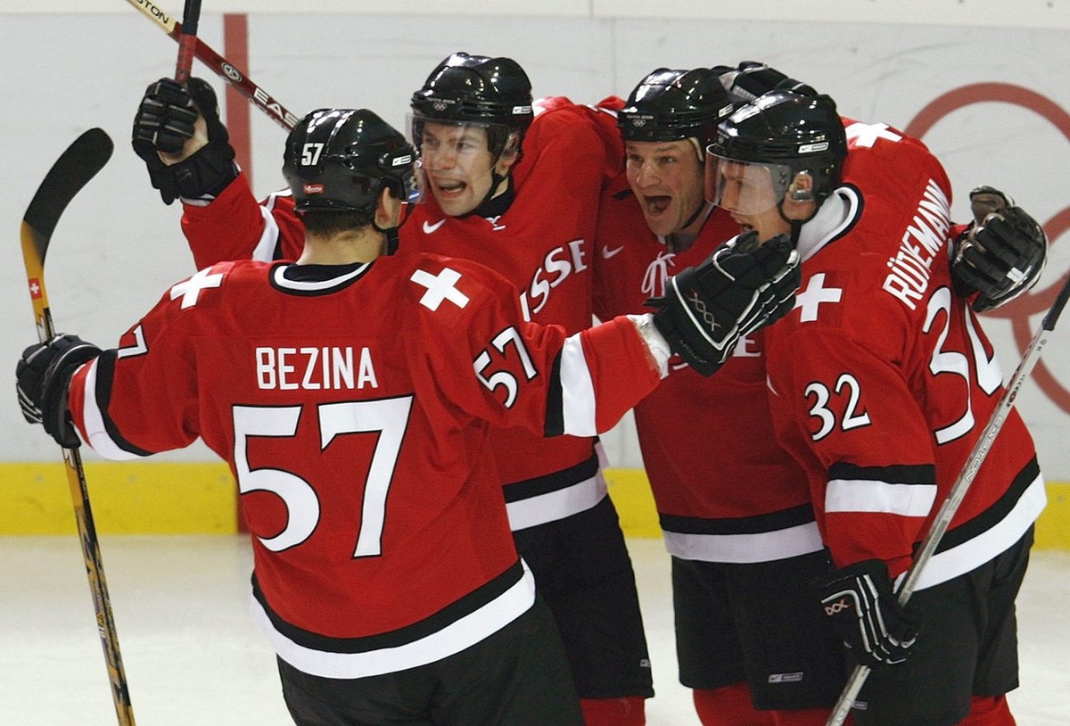 Swiss Goran Bezina, Martin Pluess, Paul di Pietro and Ivo Ruethemann, from left, celebrate di Pietros second goal, during their men's preliminary round group A ice hockey match Canada against Swi ...