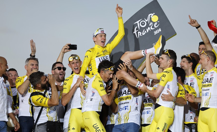 epaselect epa11490705 UAE Team Emirates riders and staff lift Yellow Jersey and Tour de France overall winner Slovenian rider Tadej Pogacar in celebration on the podium after the 21st and final stage  ...