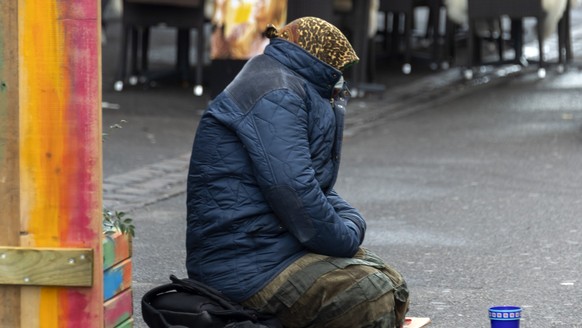Eine Bettlerin sitzt auf dem Boden in der Steinentorstrasse in Basel, am Freitag, 20. November 2020. (KEYSTONE/Georgios Kefalas)
